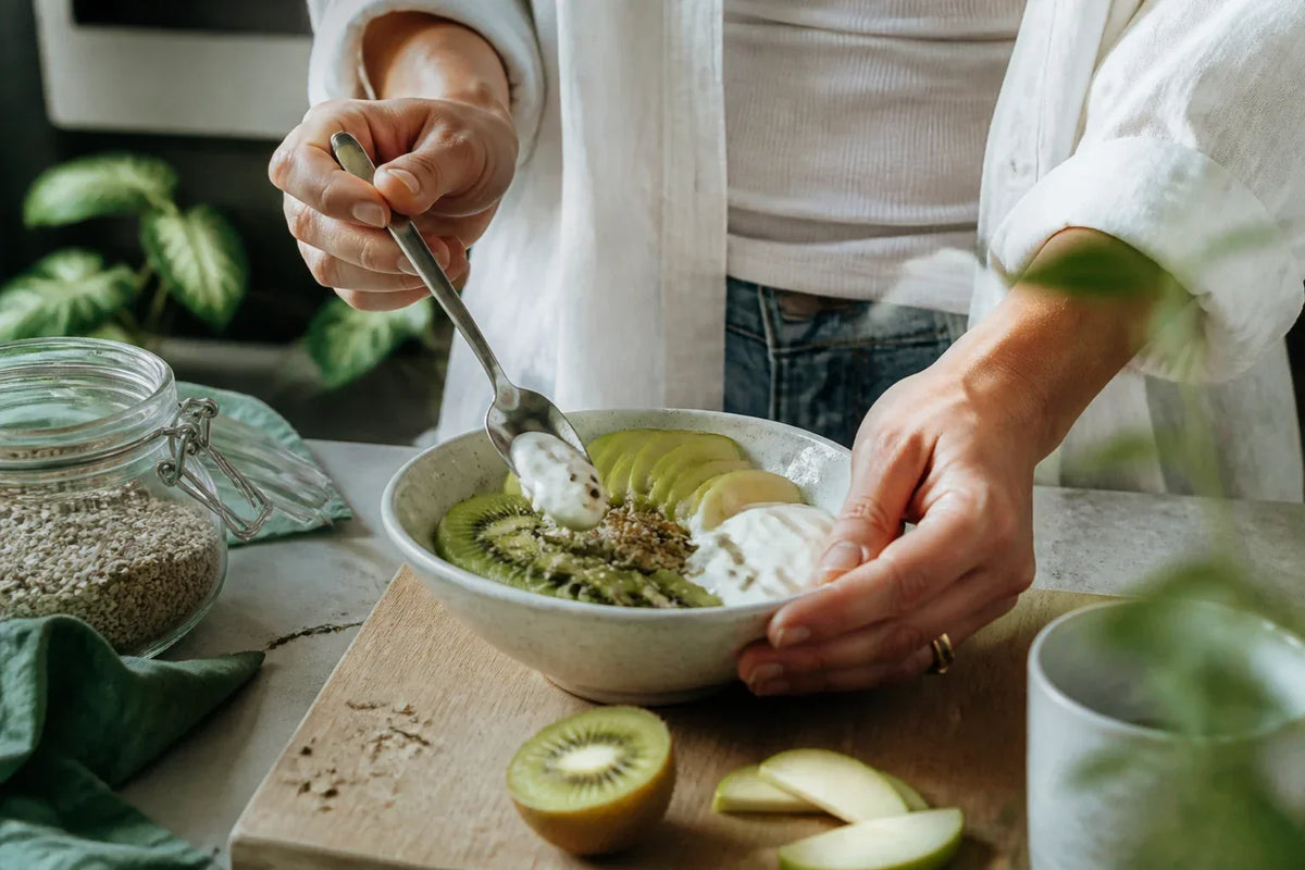 A bowl of oats, lentils, vegetables and a glass of water on a kitchen table