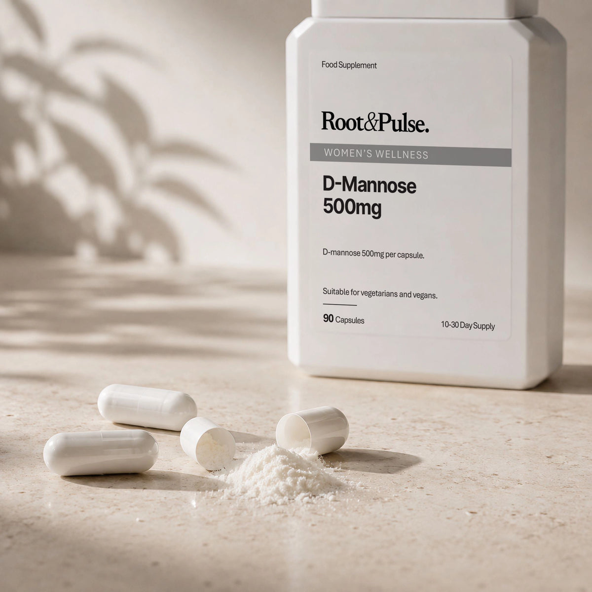 A white bottle of Root&Pulse D-Mannose 500mg food supplement stands on a light stone surface with several capsules and a small pile of powder in front. The bottle label reads Root&Pulse, Women's Wellness, D-Mannose 500mg, and 90 capsules.