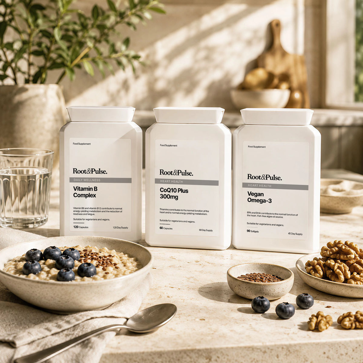 Three white supplement bottles from Root and Pulse are arranged on a stone countertop with bowls of oats, blueberries, walnuts, and a glass of water in a warm, sunlit kitchen setting.
