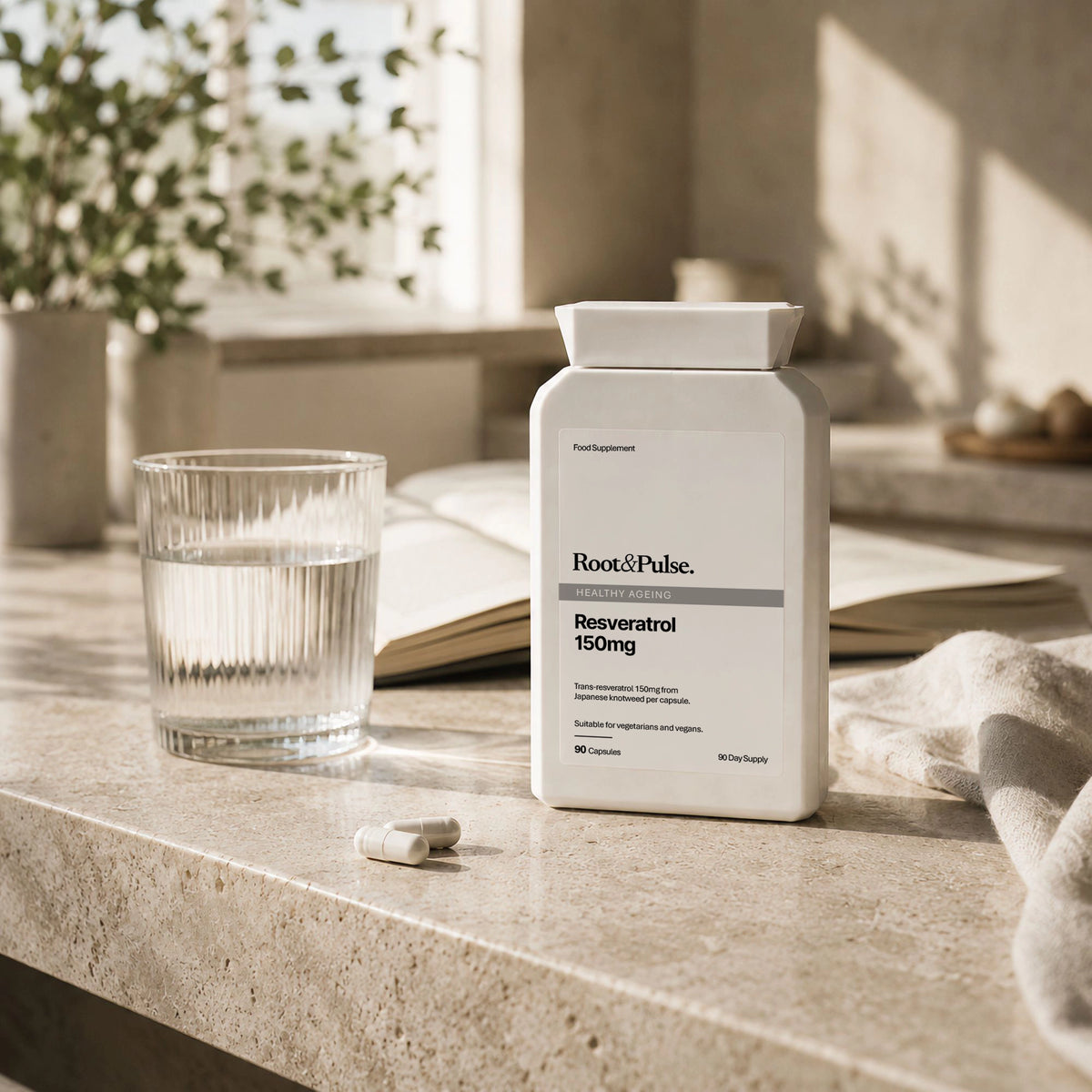 A white bottle of Root & Pulse Resveratrol 150mg dietary supplement stands on a light stone countertop beside a glass of water and two capsules, with an open book and soft natural light in the background.