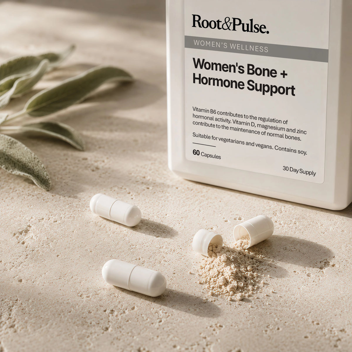 Root & Pulse Women's Bone + Hormone Support supplement bottle on a sandy surface with capsules and powder scattered nearby, plus soft-focus leaves in the background.